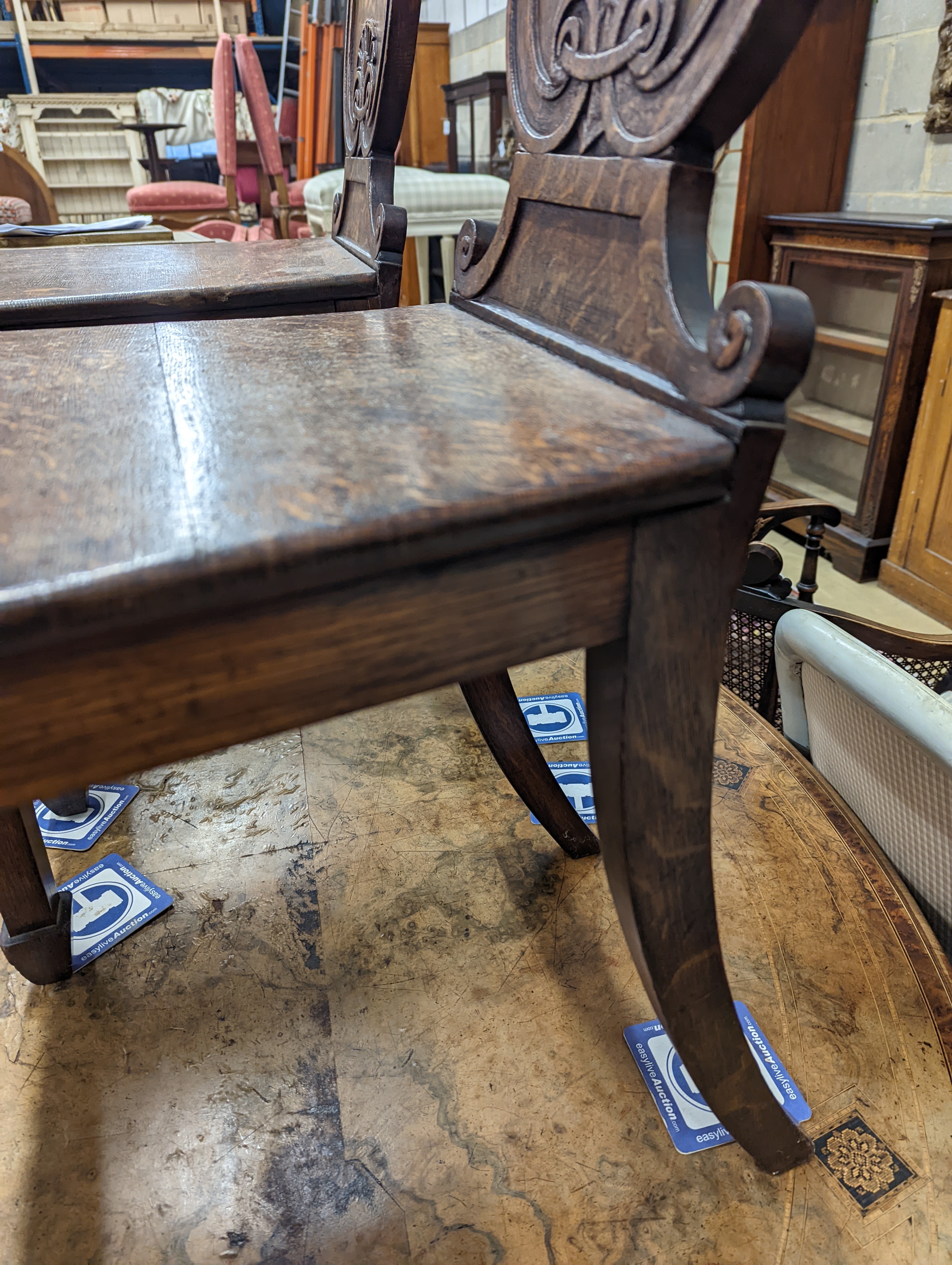 A pair of Victorian oak hall chairs with painted armorials, width 43cm, depth 39cm, height 94cm